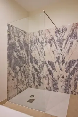 a bathroom with a shower with a marble wall at Ribeira - Dixos Oporto Apartments III in Porto