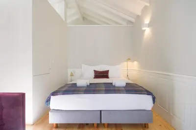 a bedroom with a bed in a white room at Porto Toja Apartments in Porto