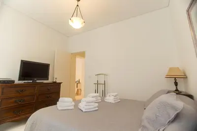 a bedroom with a bed and a tv and towels at Sweet Bainharia by Porto City Hosts in Porto