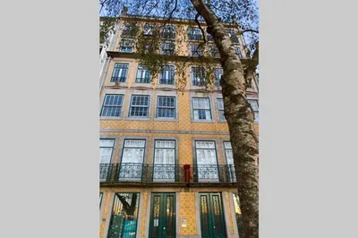 a tall building with a tree in front of it at Virtudes Terrace in Porto