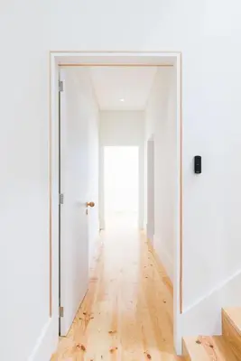 an open door in a white room with a wooden floor at Guest House Arca de Água in Porto