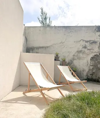 two white chairs sitting next to a wall at Guest House Arca de Água in Porto