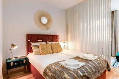 a bedroom with a large bed with a large window at Vintage Luxury House in Porto