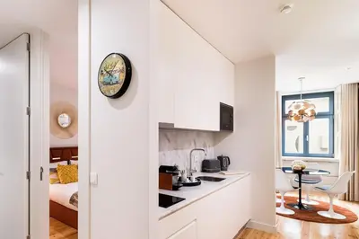 a white kitchen with a clock on the wall at Vintage Luxury House in Porto