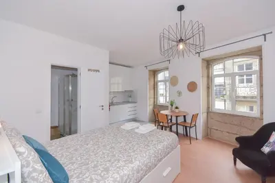 a bedroom with a bed and a table with chairs at Porto Downtown River in Porto