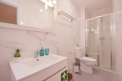a white bathroom with a sink and a toilet at Porto Downtown River in Porto