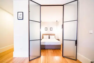 a bedroom with glass doors leading to a bed at Morar Apartments Porto in Porto