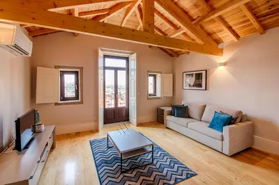 a living room with a couch and a tv at Morar Apartments Porto in Porto