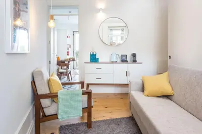 a living room with a couch and a mirror at Alegria 283 in Porto