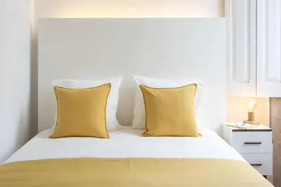 a bedroom with a bed with yellow pillows at Alegria 283 in Porto