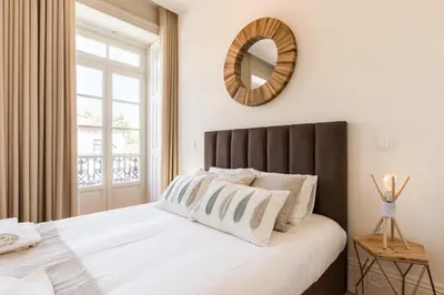 a bedroom with a large bed with a mirror on the wall at Wine Luxury House in Porto