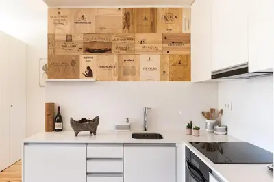 a kitchen with white cabinets and wooden boxes at Wine Luxury House in Porto