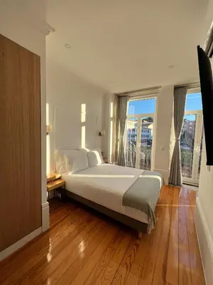 a bedroom with a large bed and a large window at Oportoflag center in Porto