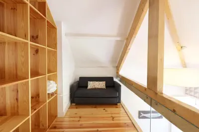 a room with a black chair in a room with wooden shelves at FLH Porto City Mezzanine Apartment in Porto