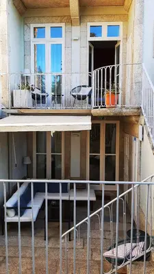 a balcony of a house with a table and chairs at Gallery Townhouse & Home in Porto