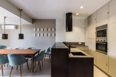 a kitchen with a wooden table and blue chairs at Gallery Townhouse & Home in Porto