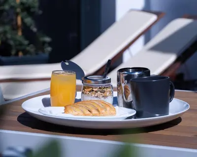 a plate of food with a cup of orange juice and a plate of bread at NorteSoul Mouzinho in Porto