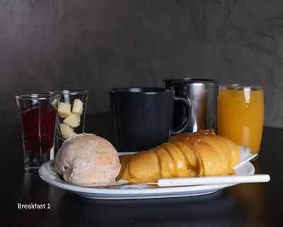 a plate of food with a loaf of bread and orange juice at NorteSoul Mouzinho in Porto