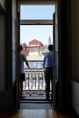 two men looking out of a door at a balcony at NorteSoul Mouzinho in Porto