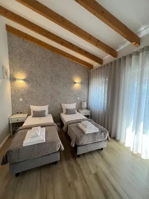 two beds in a room with wooden floors at Douro Pateo House in Vila Nova de Gaia