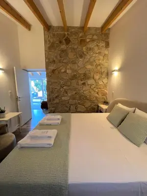 a bedroom with two beds and a stone wall at Douro Pateo House in Vila Nova de Gaia