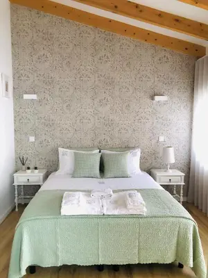 a bedroom with a large bed with a green blanket at Douro Pateo House in Vila Nova de Gaia