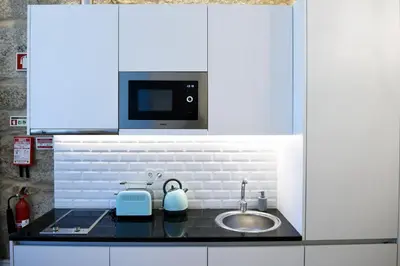 a kitchen with a sink and a microwave at Trendy Flats Fontainhas in Porto