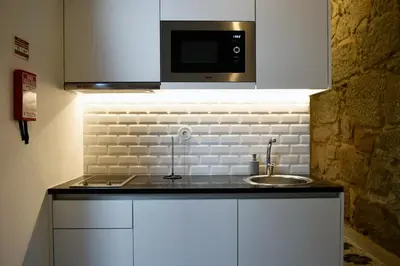 a kitchen with a sink and a microwave at Trendy Flats Fontainhas in Porto