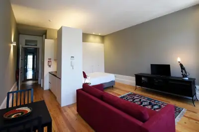 a living room with a red couch and a bed at Trendy Flats Fontainhas in Porto