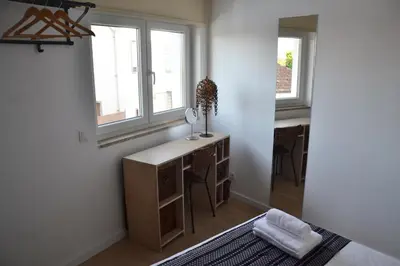 a bedroom with a desk and two windows at Portoo Blue Apartments - Amazing in Vila Nova de Gaia