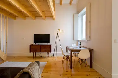 a living room with a table and a television at APOSENTUS - Clerigos Tower view Mezzanine in Porto