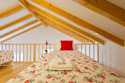 a bedroom with a bed with a red pillow on it at APOSENTUS - Clerigos Tower view Mezzanine in Porto