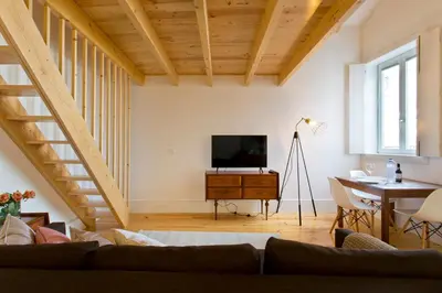 a living room with a couch and a television at APOSENTUS - Clerigos Tower view Mezzanine in Porto