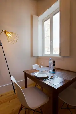 a dining room table with two chairs and a lamp at APOSENTUS - Clerigos Tower view Mezzanine in Porto