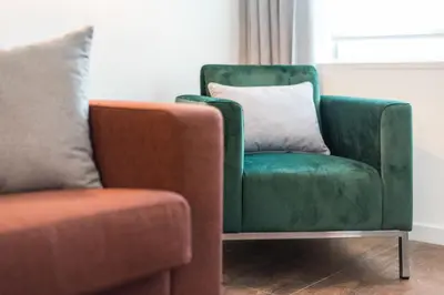 a green chair with a pillow next to a couch at Marques Design Apartments in Porto