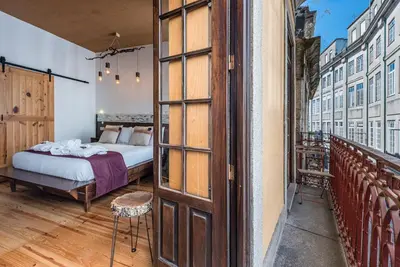 a bedroom with a bed and a stone wall at GuestReady - CastleRock Pub & Hotel in Porto