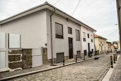 a white building on the side of a street at T2P Mimosa House in Vila Nova de Gaia