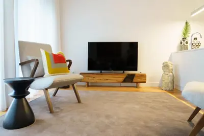 a living room with a television and a chair at Stayin Apartments - Rua do Sol in Porto