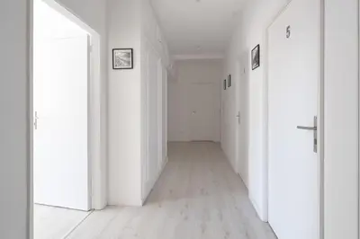 an empty hallway with white walls and wooden floors at Moreira 284 in Porto