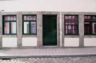 a building with a green door and four windows at OportoLuxApartments in Porto
