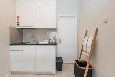 a kitchen with white cabinets and a sink at River View Building in Vila Nova de Gaia