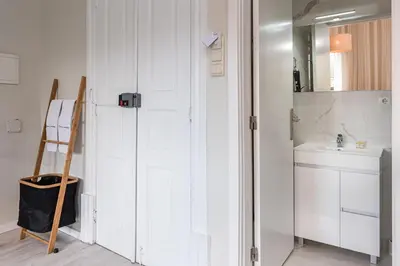 a white bathroom with a sink and a mirror at River View Building in Vila Nova de Gaia
