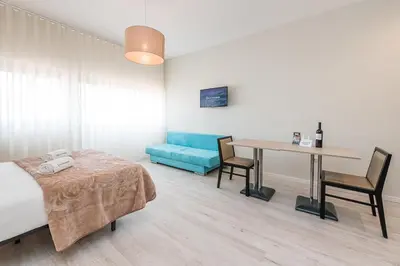 a bedroom with a bed and a table and a blue couch at River View Building in Vila Nova de Gaia