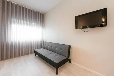 a living room with a couch and a flat screen tv at River View Building in Vila Nova de Gaia