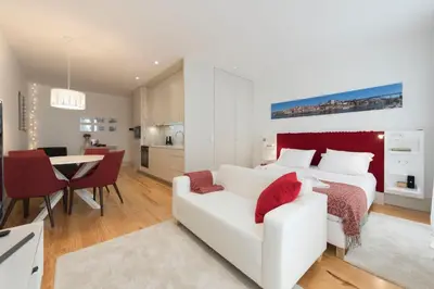 a bedroom with a white bed and a white couch at Heart of D Pedro Apartments in Porto
