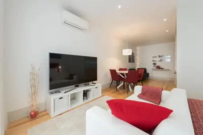 a living room with a white couch and a flat screen tv at Heart of D Pedro Apartments in Porto