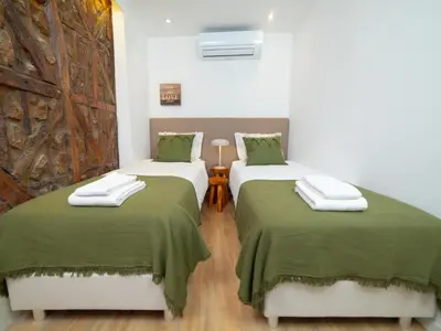 two beds in a room with green sheets at Ponte D Luis I Apartments in Porto
