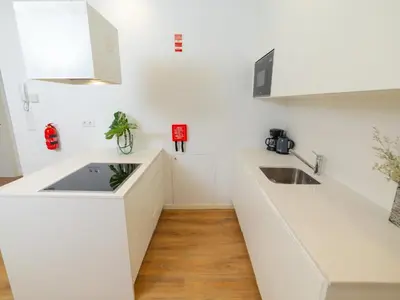 a kitchen with white counters and a sink at Ponte D Luis I Apartments in Porto