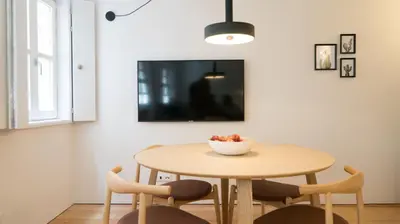 a dining room table with chairs and a bowl of fruit on it at Souto Apartments in Porto