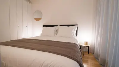 a bedroom with a large white bed and a table at Souto Apartments in Porto